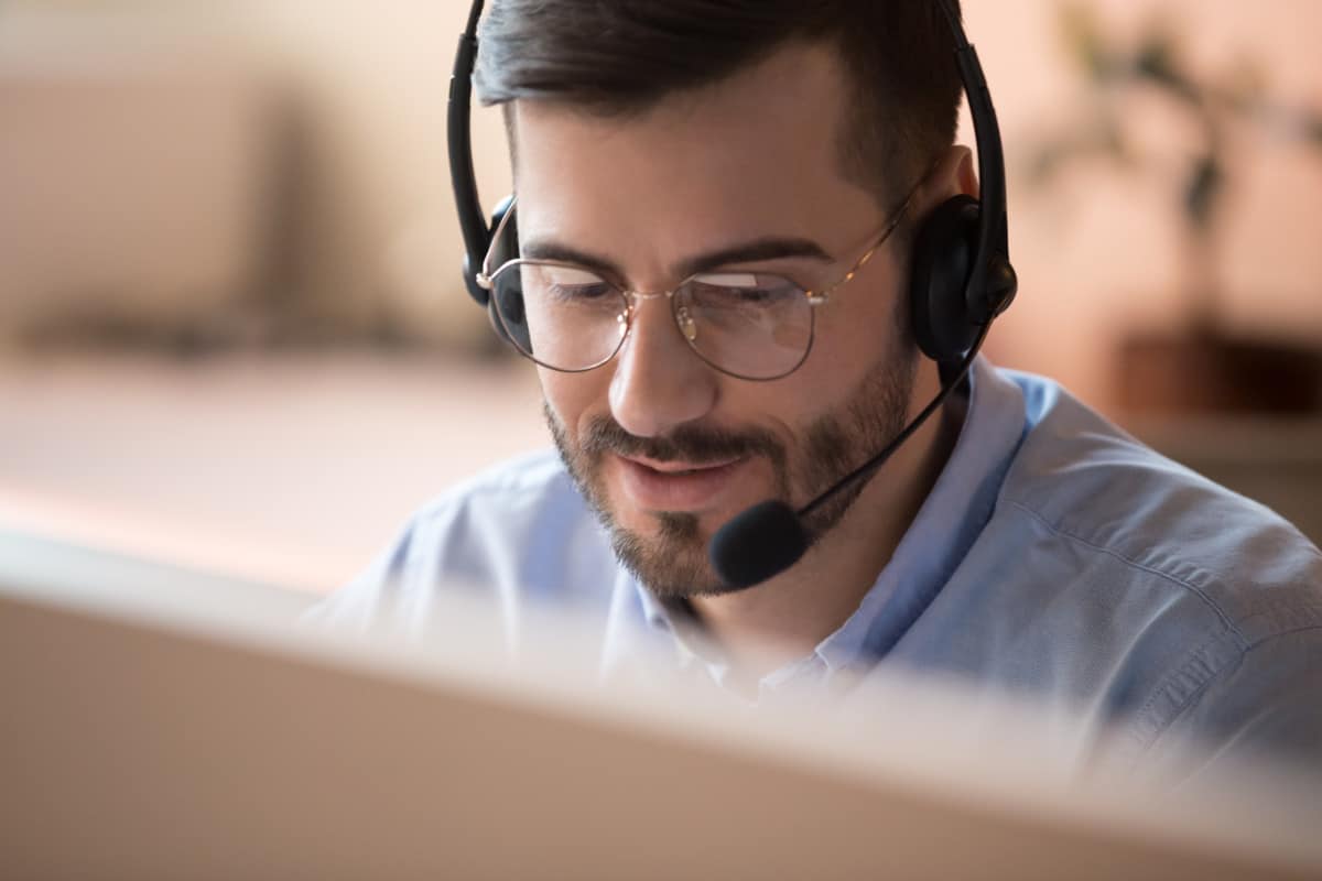 IT-Service, Support, First Level Support, Service, Focused businessman telemarketer telesales agent wear wireless headset make conference video call talk consult online client on computer, male helpline operator work in customer care support office